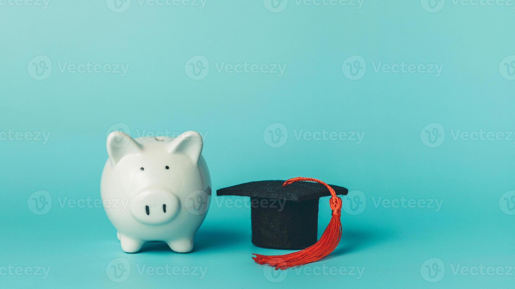Piggy bank with graduation cap on blue background. Education concept. photo