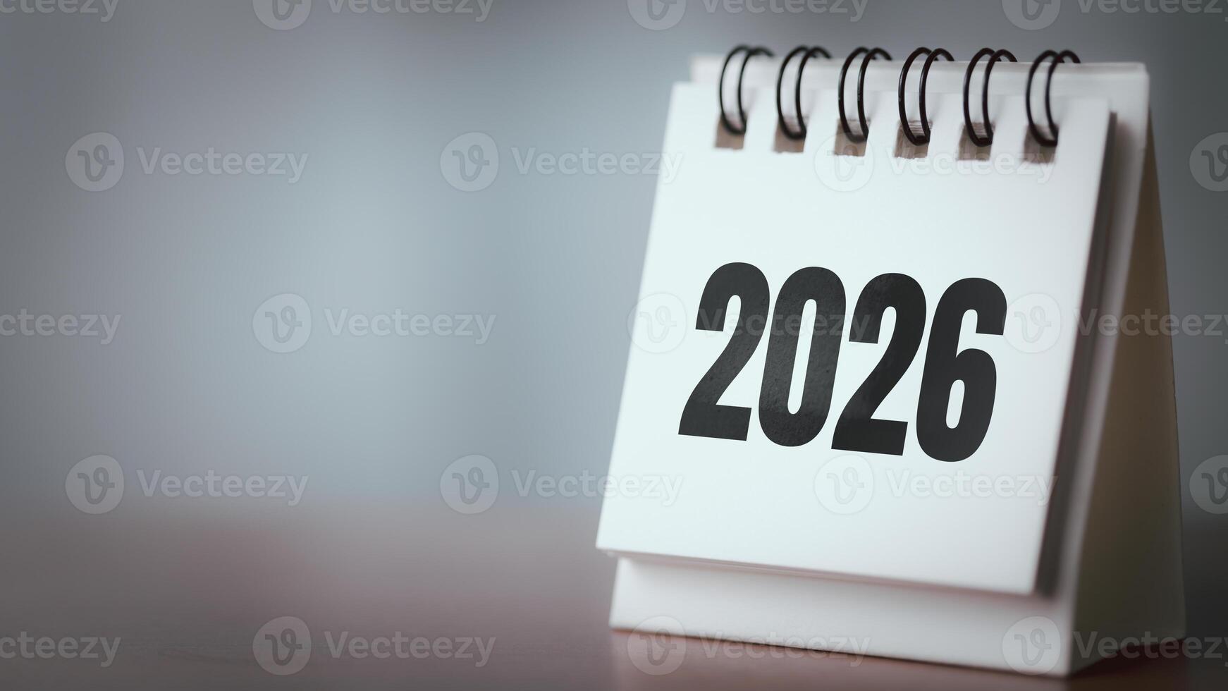 Desk Calendar Showing 2026 on Wooden Table with Blurred Background and Copy Space photo