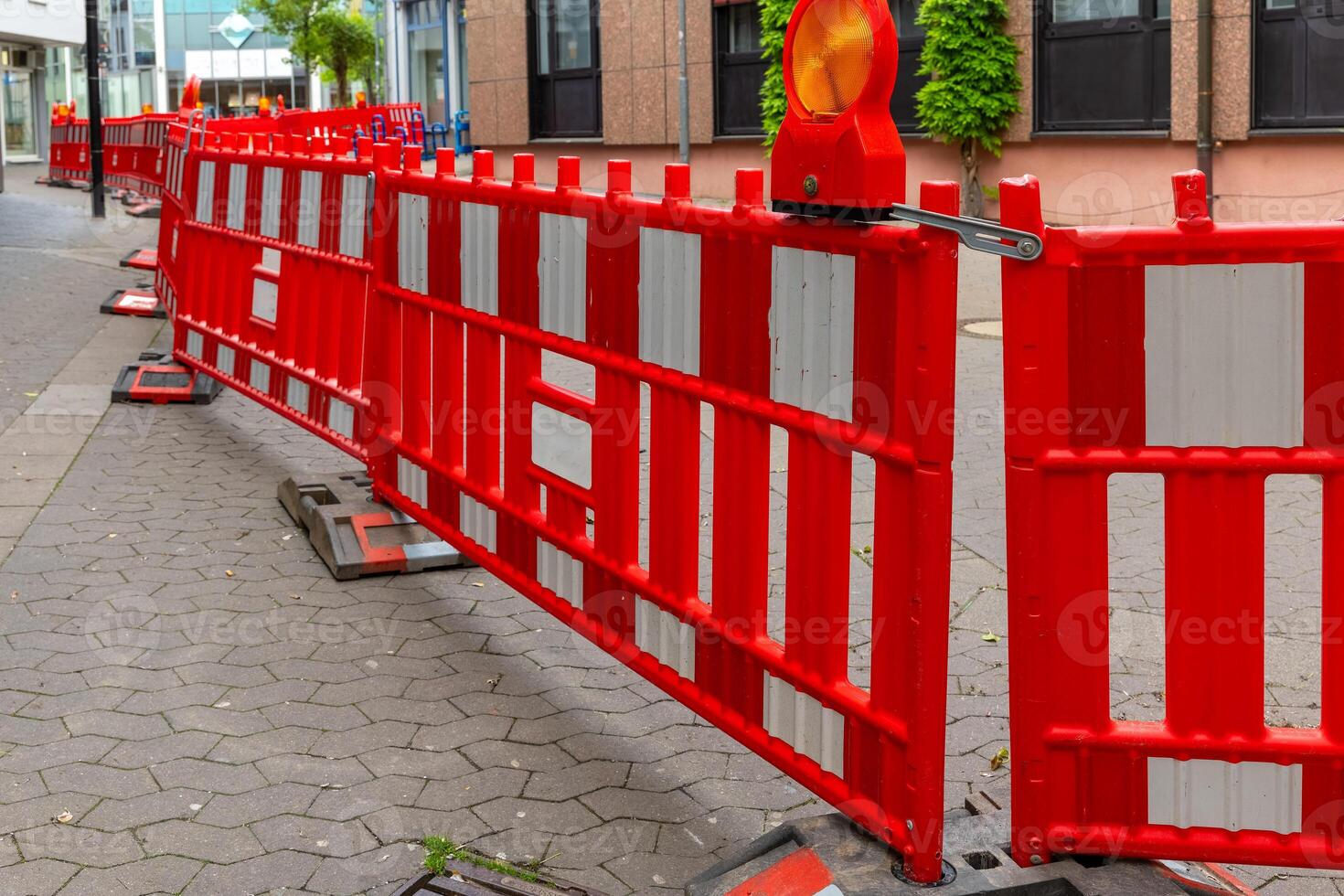 Bright red barriers create a striking contrast against urban architecture during street repairs on a crisp day in a bustling neighborhood photo