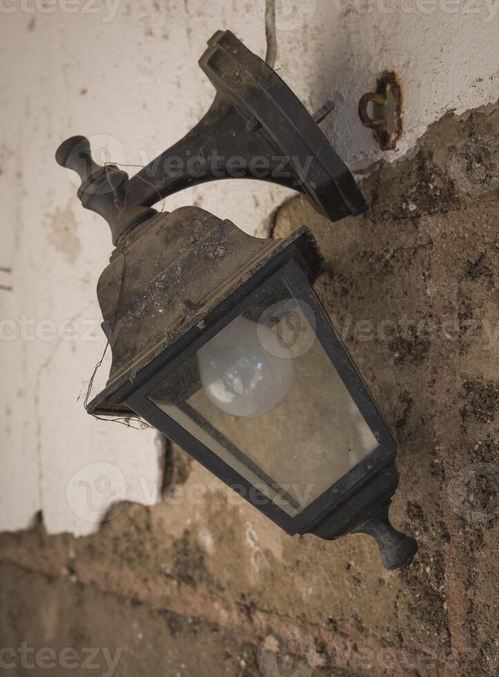 Rustic lantern hangs at an abandoned site, casting an aura of nostalgia and mystery in the dim light of dusk photo