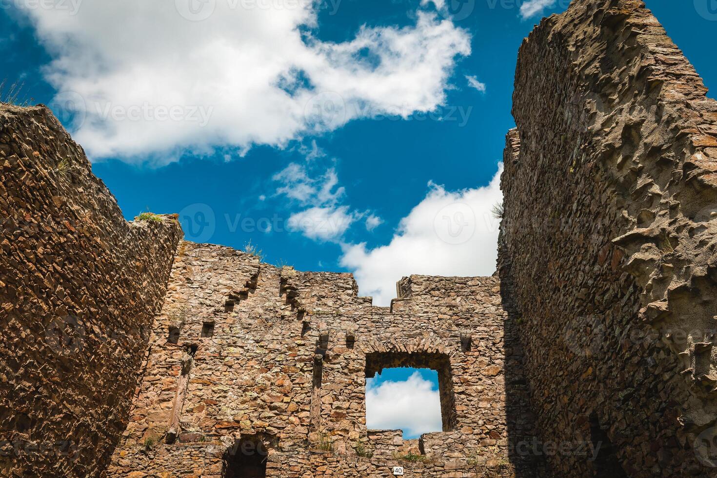 Exploring ancient stone ruins against a vibrant blue sky on a sunny day photo