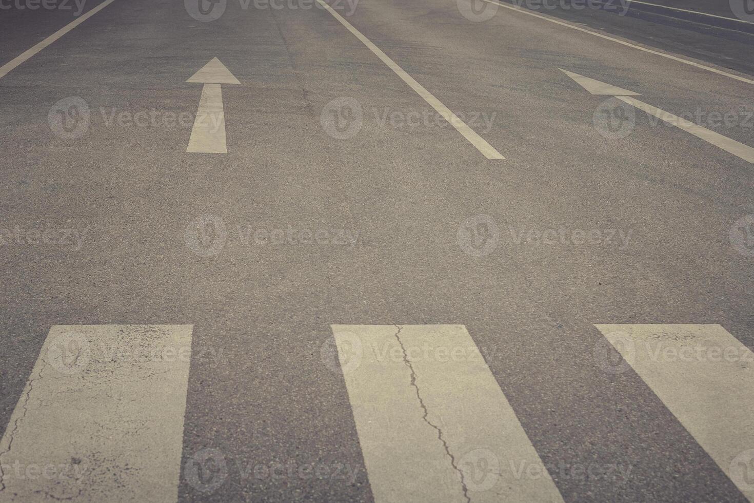Guiding lines on an empty street stretch toward the horizon under a cloudy sky at dusk photo