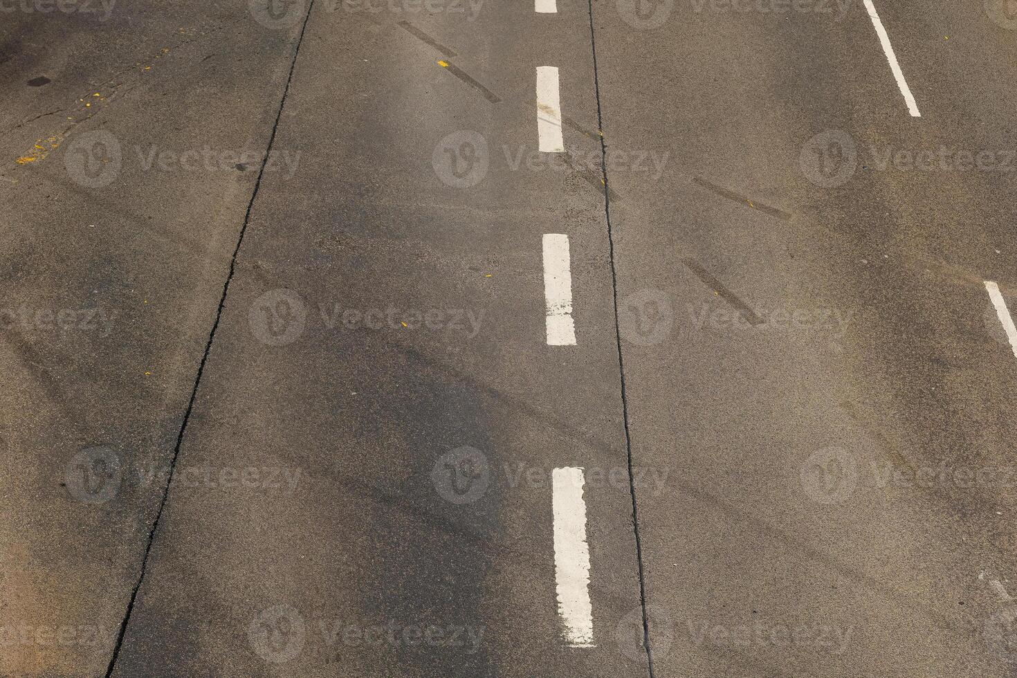Capturing the quiet afternoon on a deserted highway with subtle tire marks and faded lane lines photo