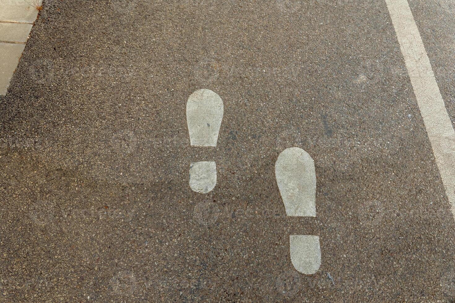 Footsteps guiding the way on a quiet urban pathway during a sunny afternoon stroll photo