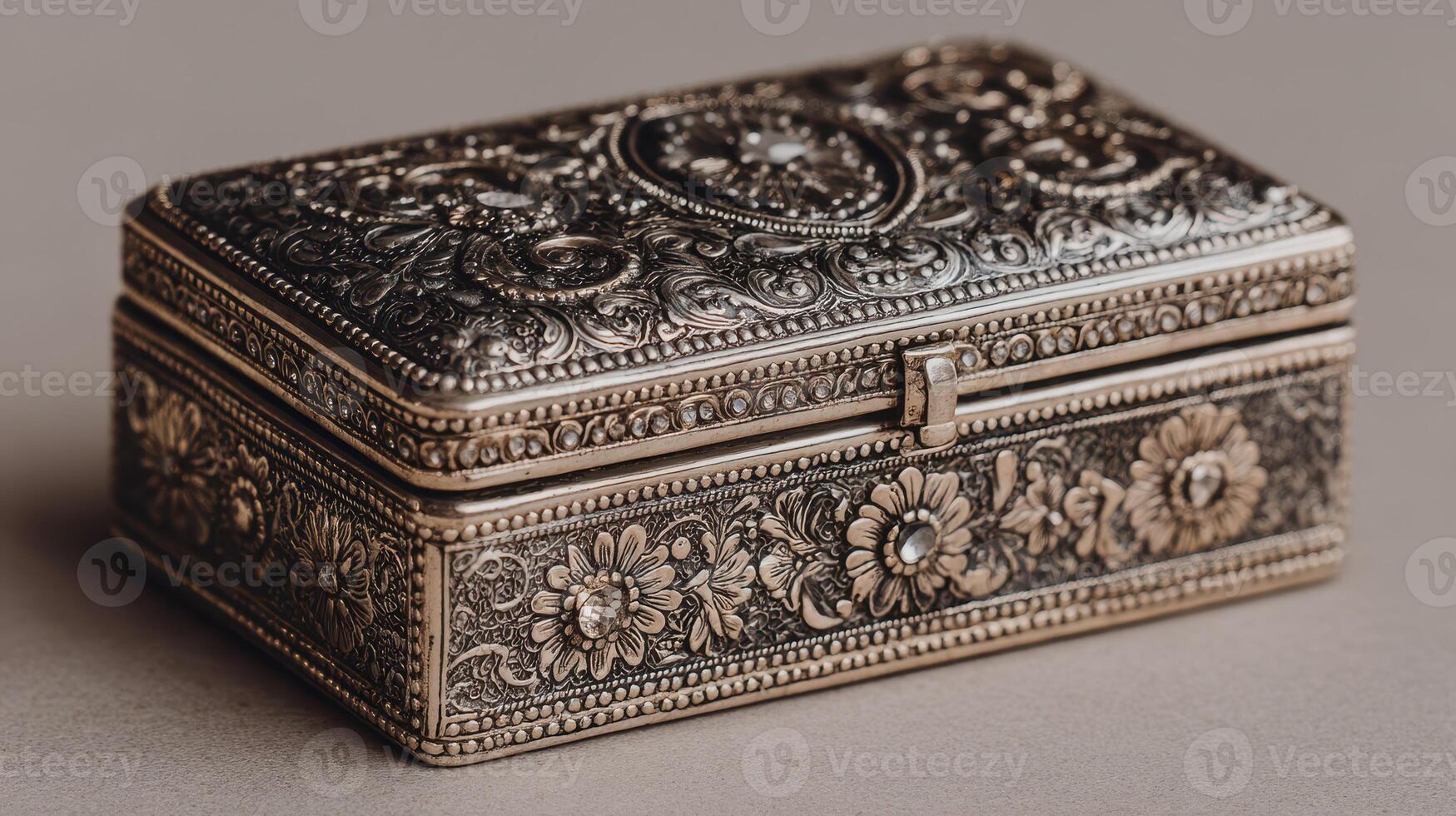 Intricate silver jewelry box with floral patterns and detailed engravings showcased on a neutral background photo