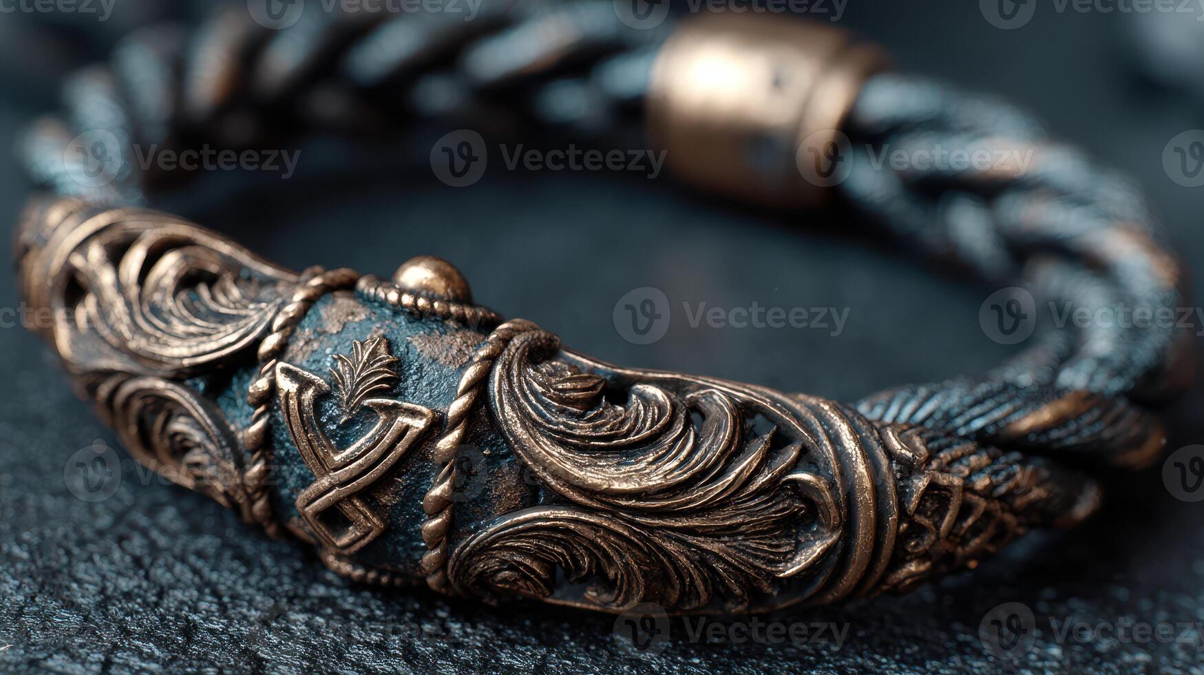 Intricate bronze bracelet with detailed craftsmanship resting on a textured surface photo