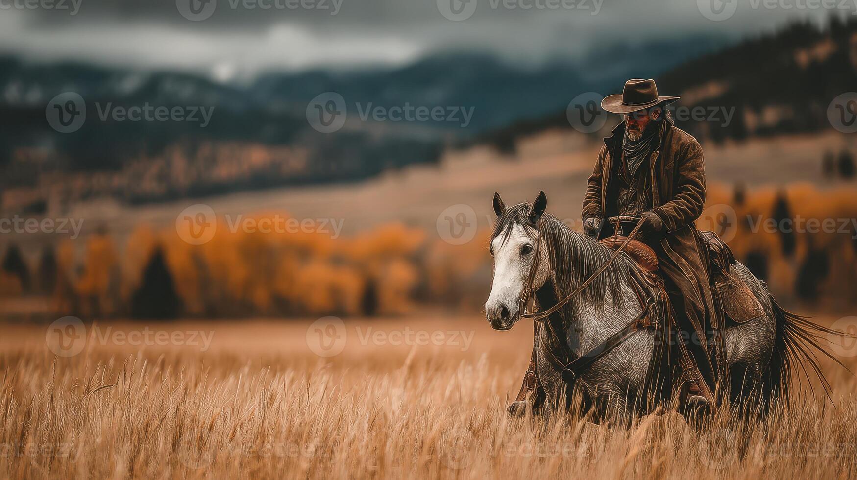 Cowboy riding a horse through golden grasslands on a cloudy autumn day photo