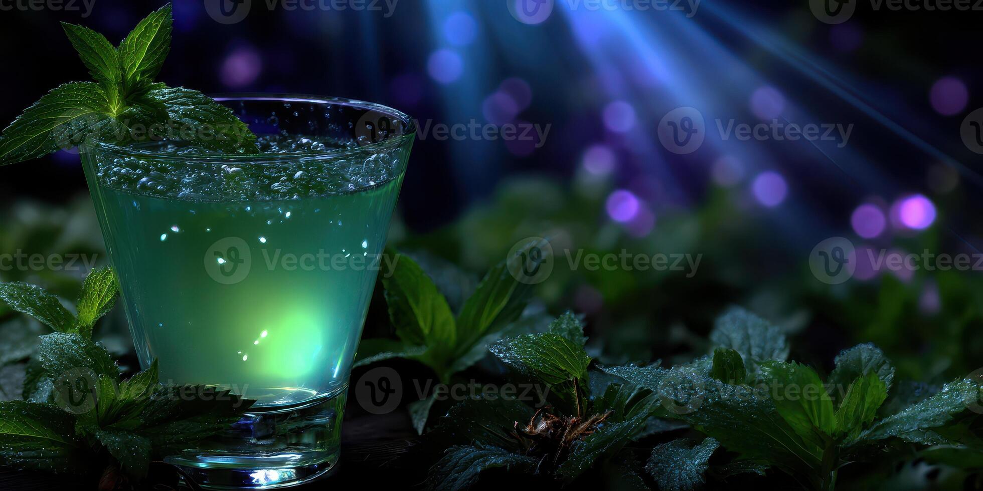 Refreshing mint beverage served in glass amidst vibrant green leaves and a soft glowing background at night photo