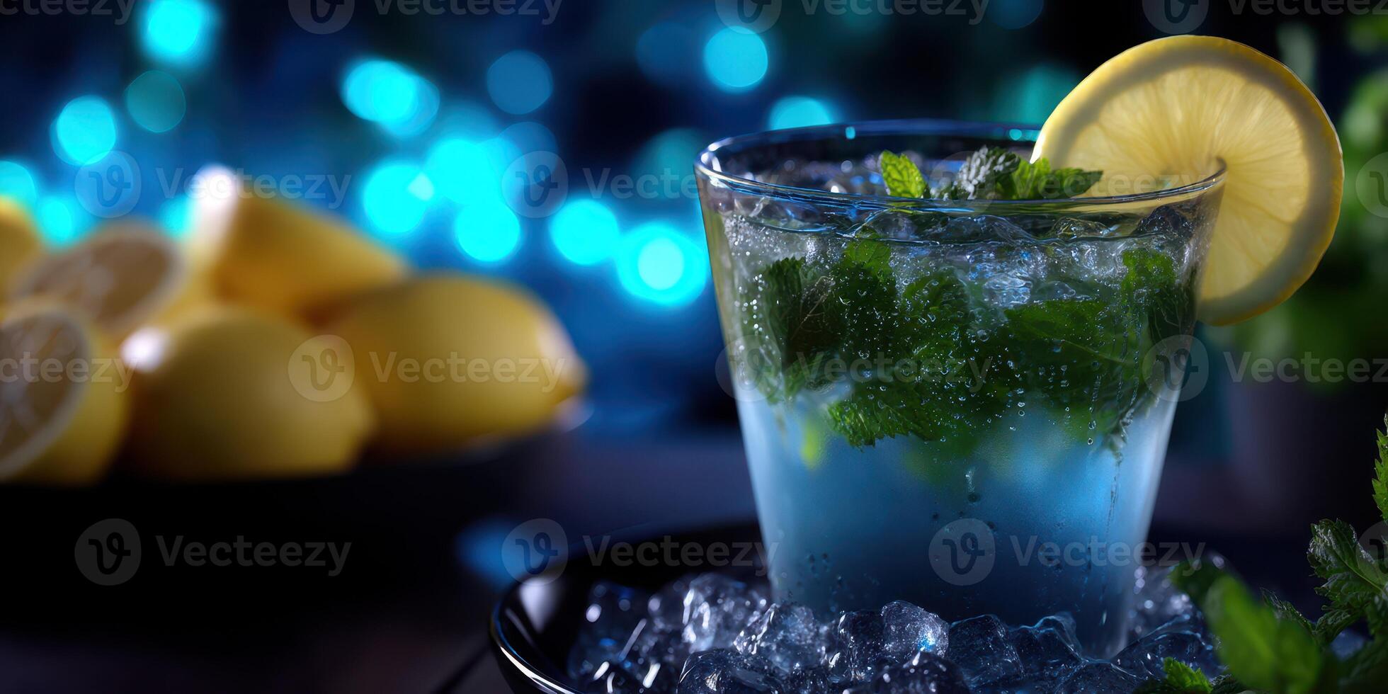 Refreshing mojito served in a glass with fresh mint and lemon slice against a blue background with lemon halves in the frame photo