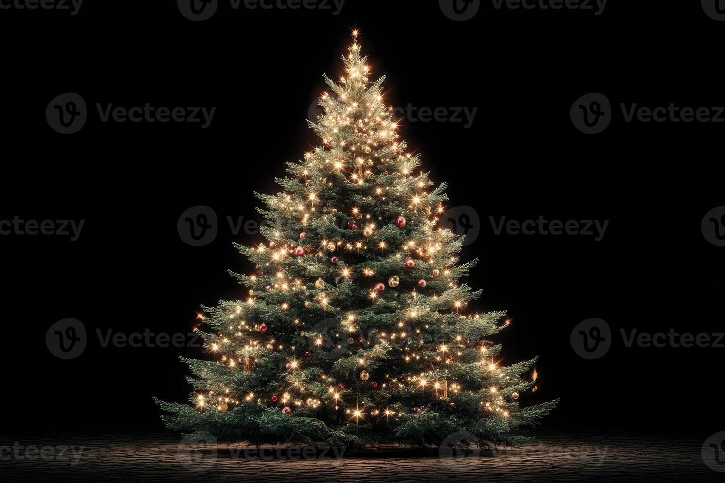 Decorated Christmas tree illuminated with lights and ornaments in dark setting photo