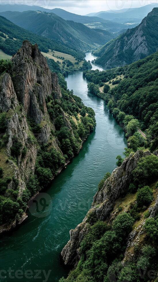 Breathtaking view of a winding river flanked by rocky cliffs and lush greenery in a serene landscape photo