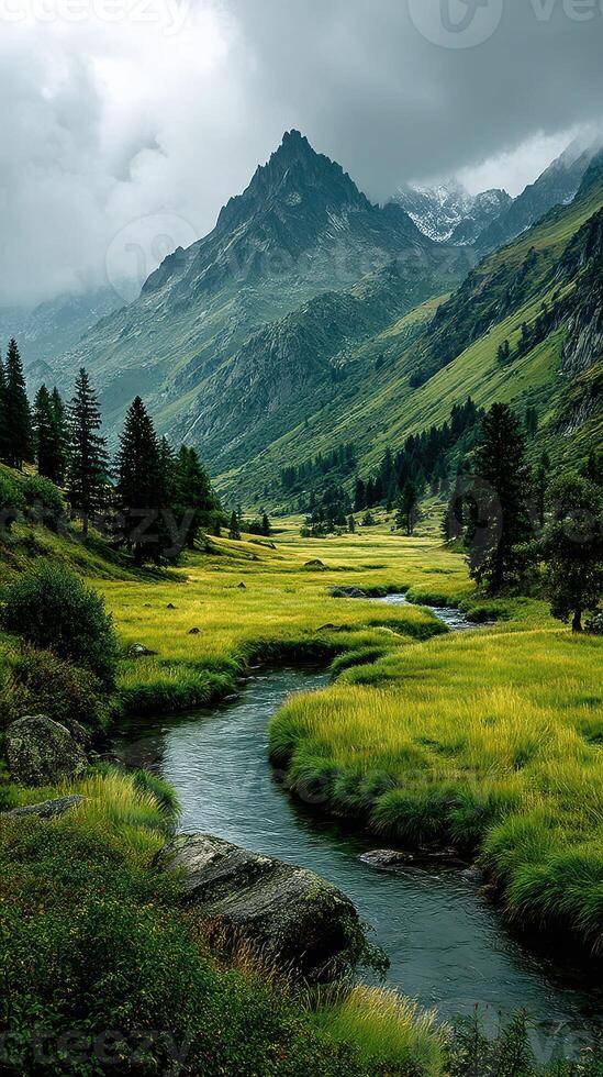 Majestic mountains towering over a lush green valley with flowing river under overcast sky photo