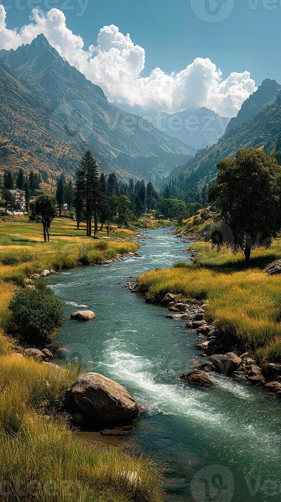 Serene river flows through lush valley surrounded by mountains under a bright sky photo