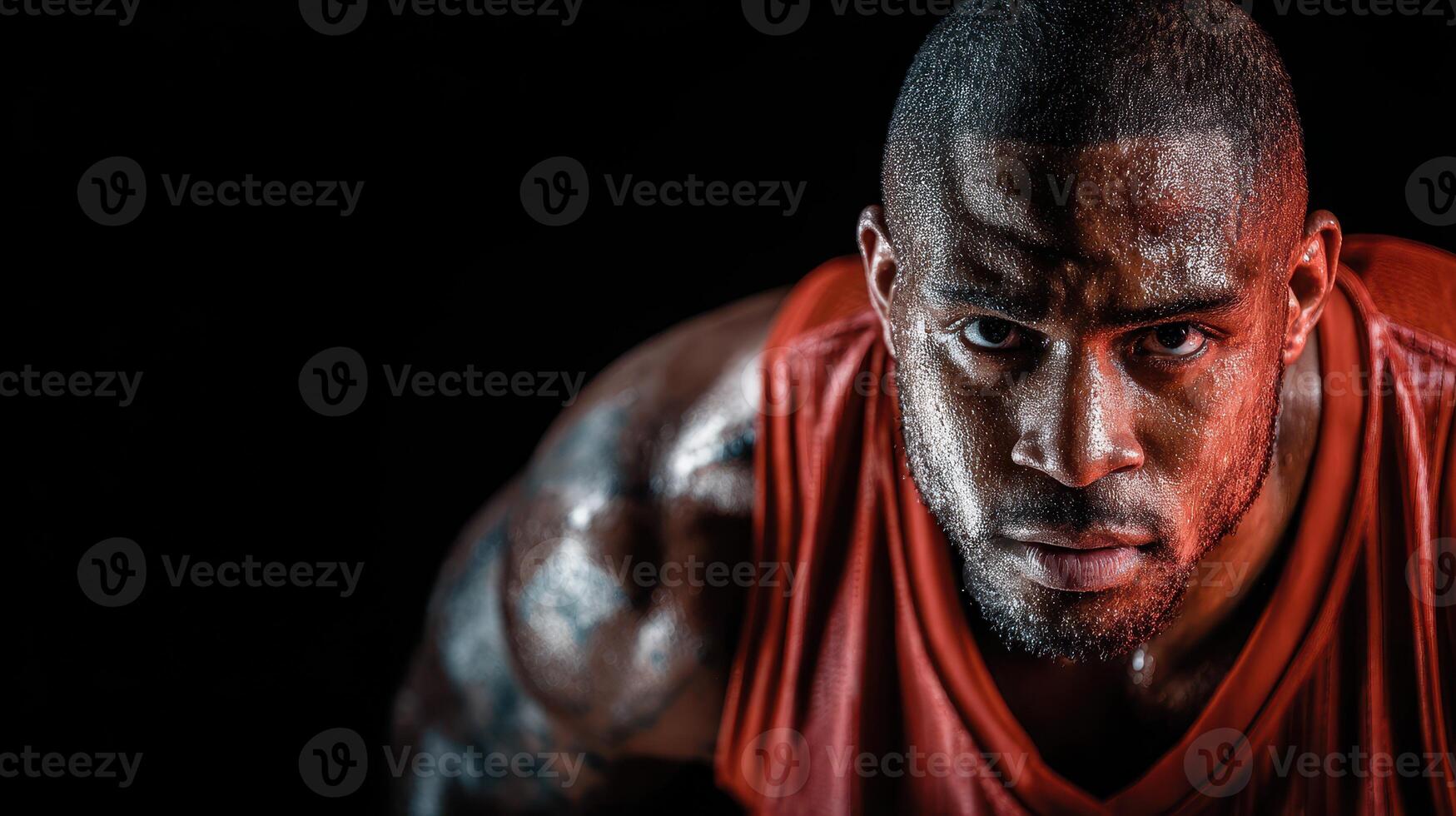 Athlete shows intense focus and determination during workout in a dark gym environment with dramatic lighting photo
