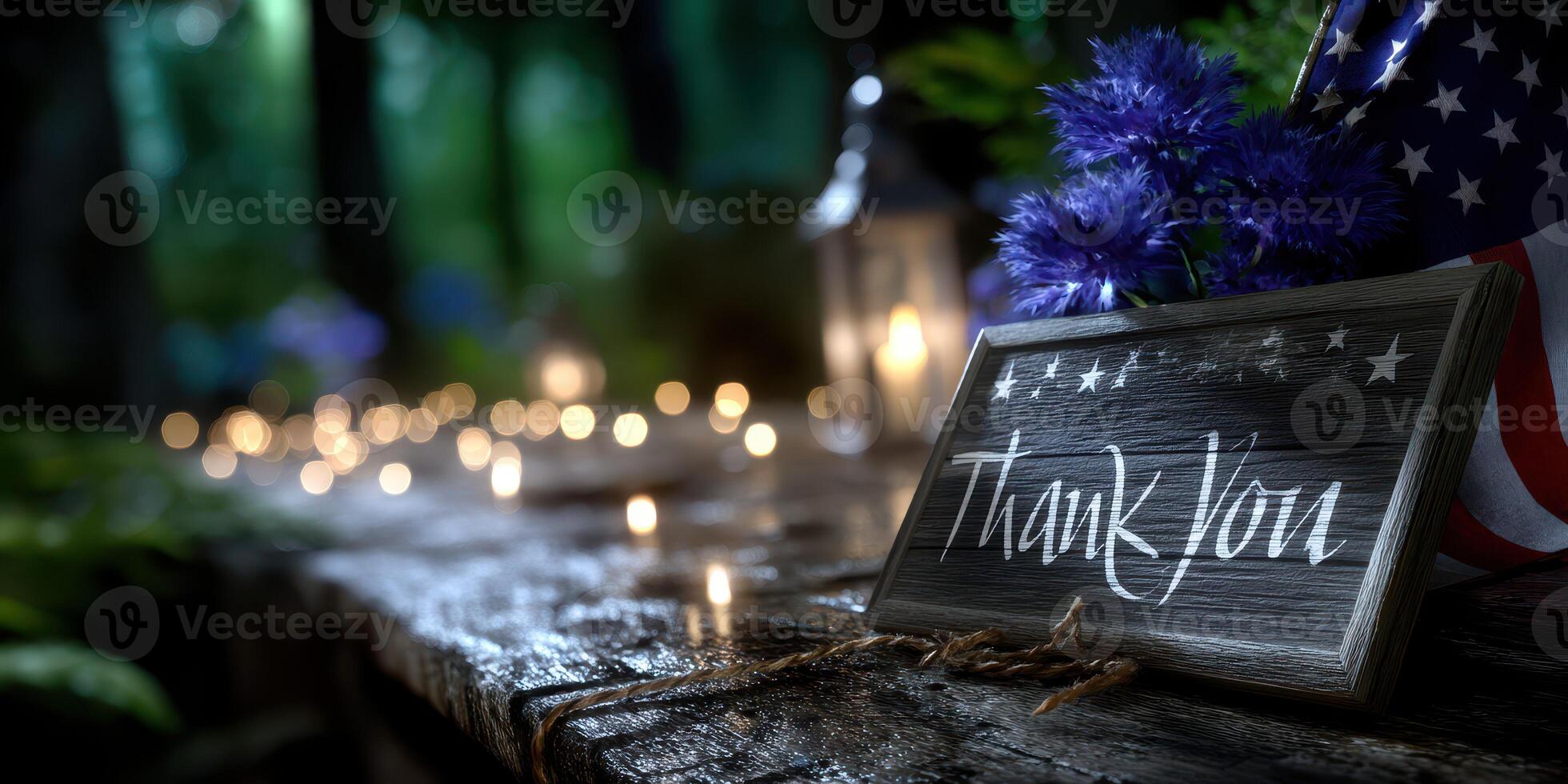 Wooden thank you sign surrounded by candles and flowers in a forest setting at night during a gathering photo