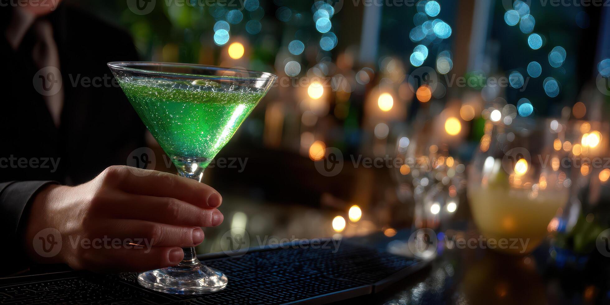 Bartender serves vibrant green cocktail at a dimly lit bar during evening hours photo
