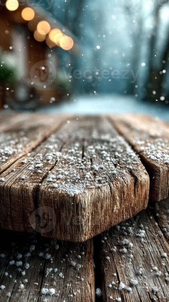 Snowflakes gently falling on a rustic wooden table in a serene winter landscape photo