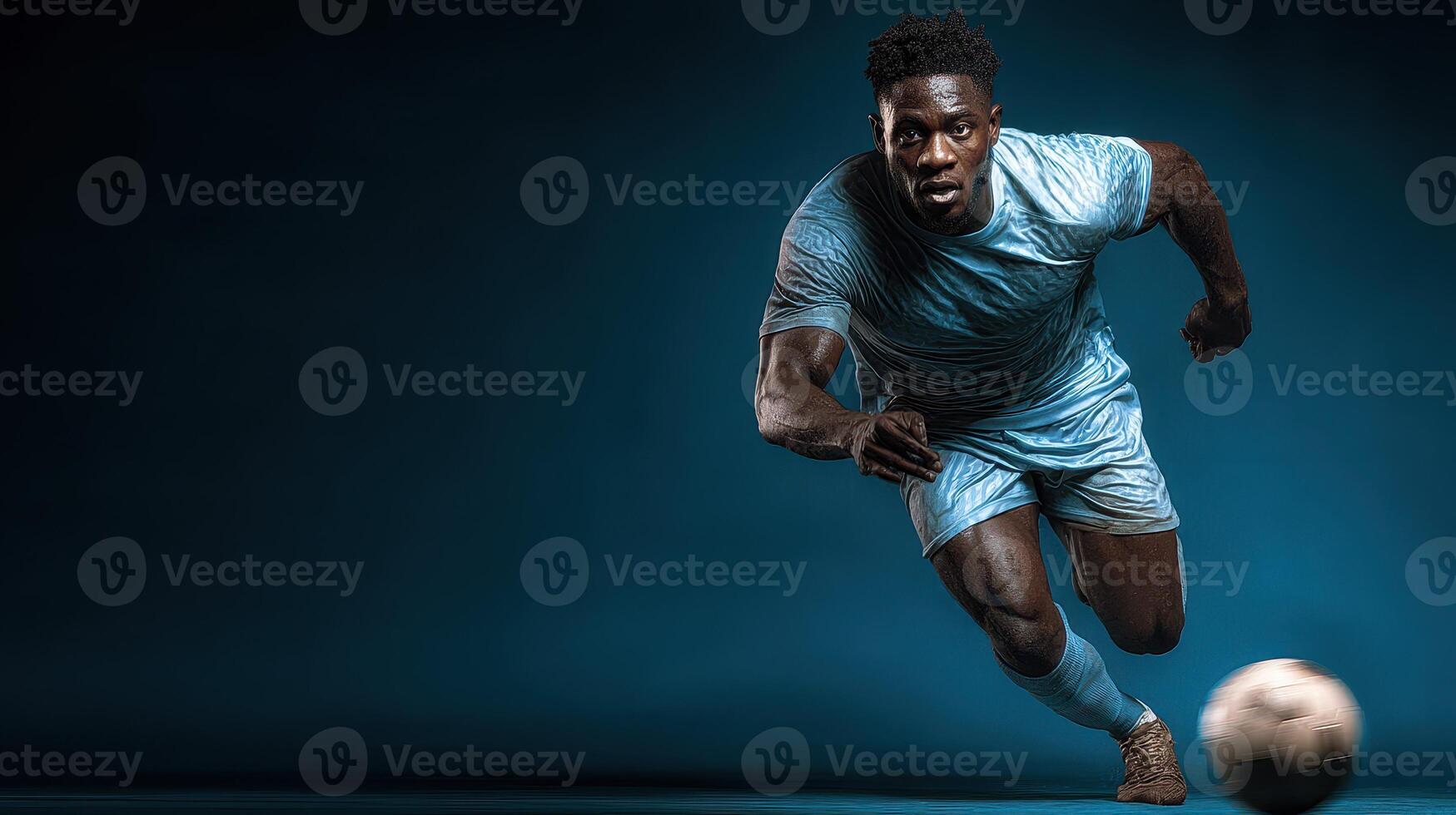 Athlete in blue soccer uniform sprinting with focus on a dark background during an intense match photo