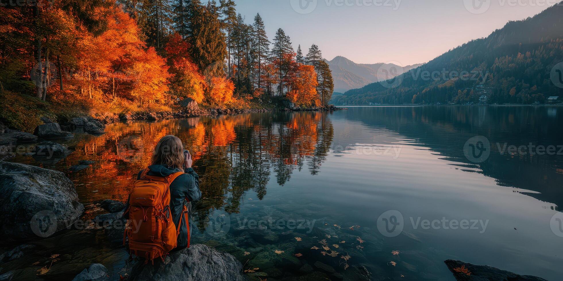 Capturing autumn reflections by the tranquil lake surrounded by mountains at sunrise photo
