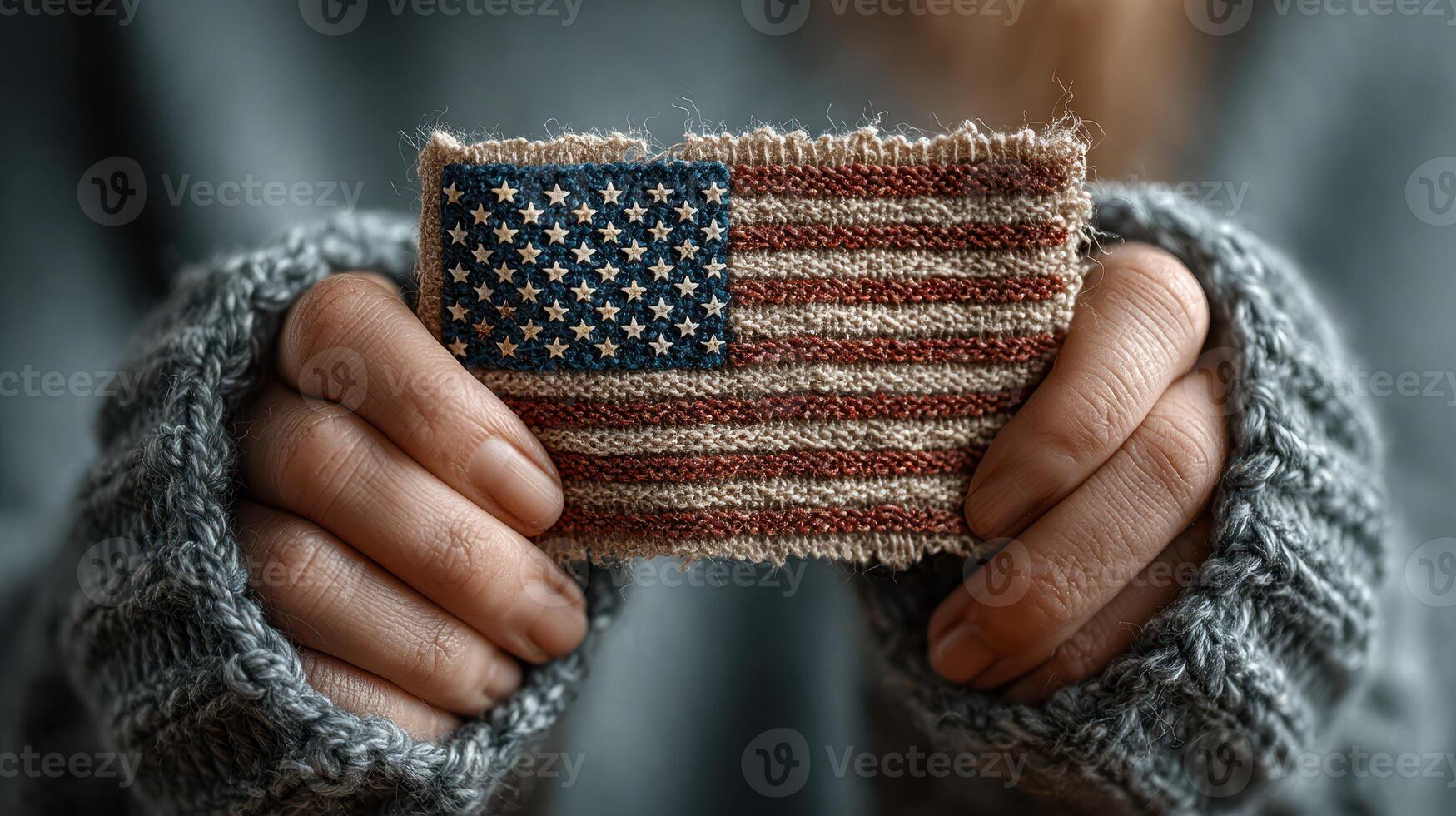 Hands hold a vintage American flag patch while wearing a cozy sweater in a warm, inviting atmosphere photo