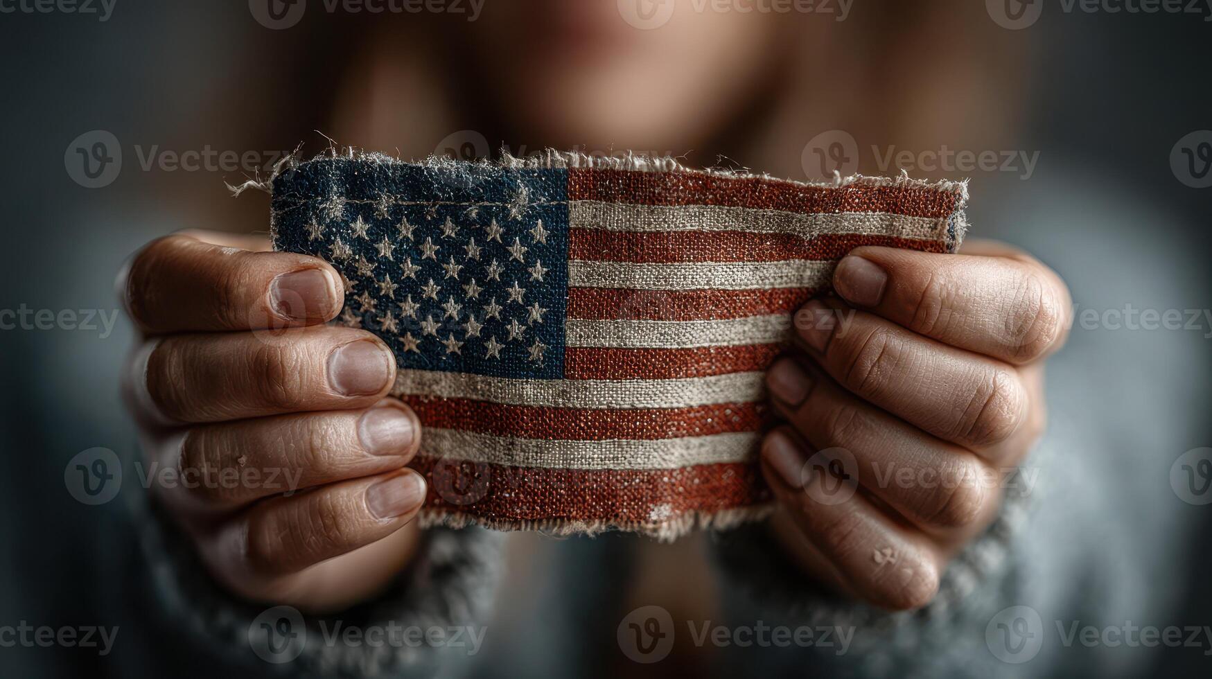 Holding a worn American flag patch in hands, representing patriotism and tradition in a close-up setting photo