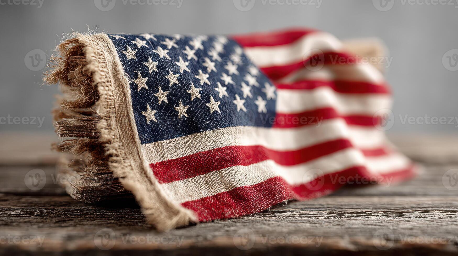 Faded American flag draped over a rustic wooden surface with a textured background showcasing its vintage charm photo