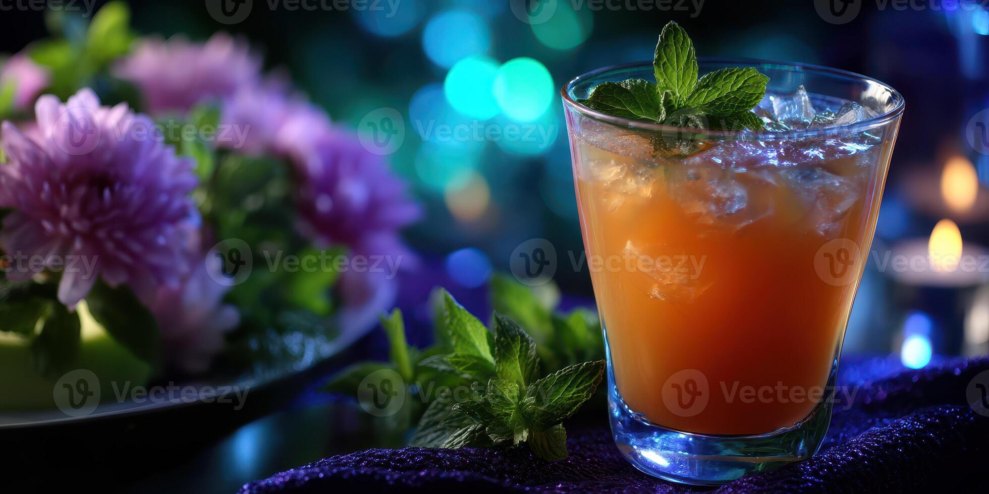 Refreshing beverage with ice and mint displayed beside colorful flowers on a stylish table in soft lighting at evening gathering photo