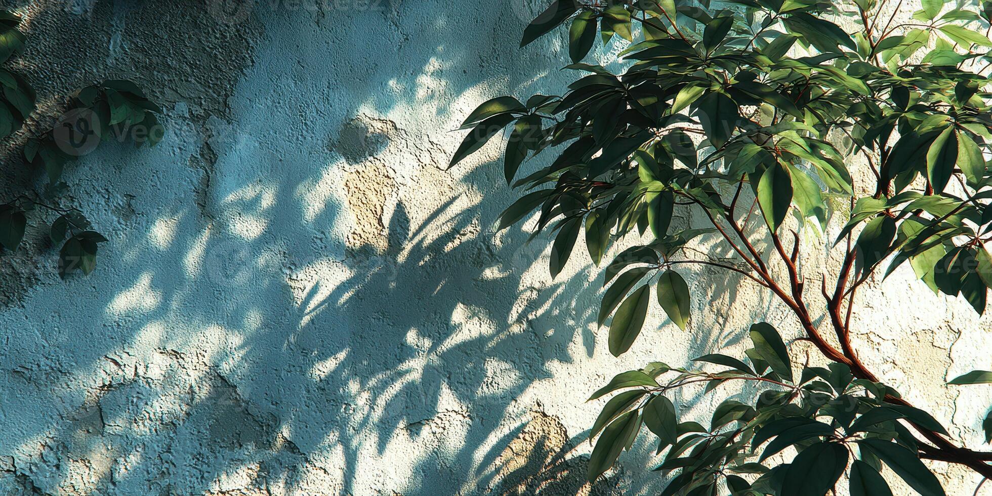 Sunlight casts shadows of green leaves on a textured blue wall in an outdoor setting during a sunny afternoon photo