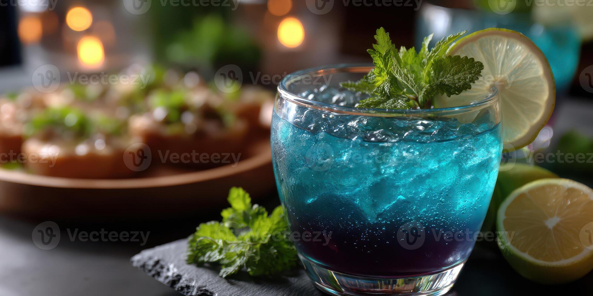 Refreshing blue cocktail with mint and lime served at an evening gathering photo