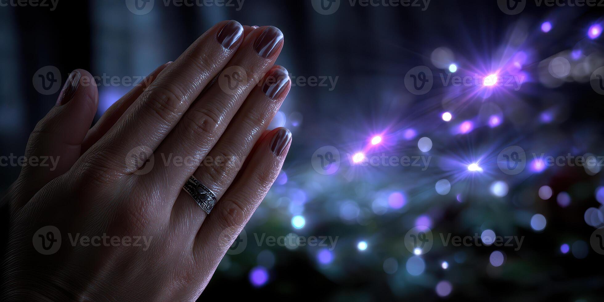 Hands in a prayer position with shimmering lights in the background during a spiritual moment at dusk photo