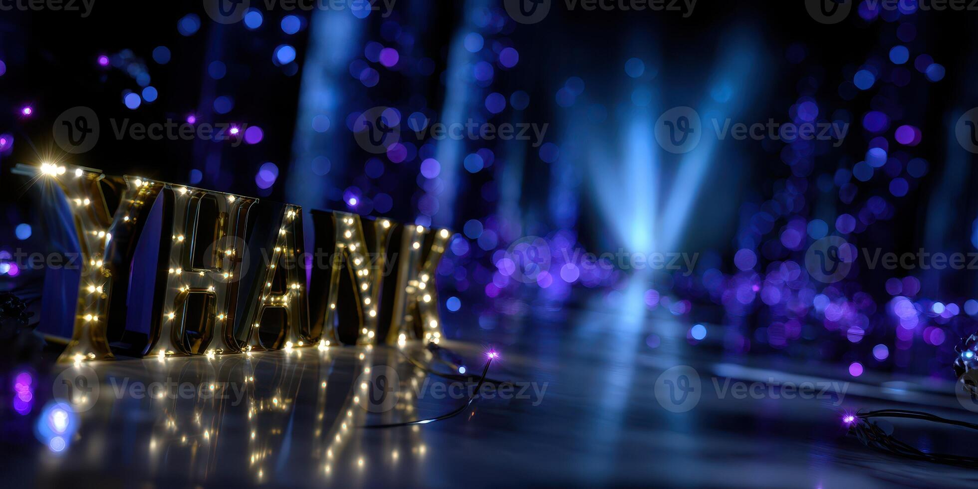 Decorative lights spell thank on a dark stage with purple bokeh in the background during an evening event photo