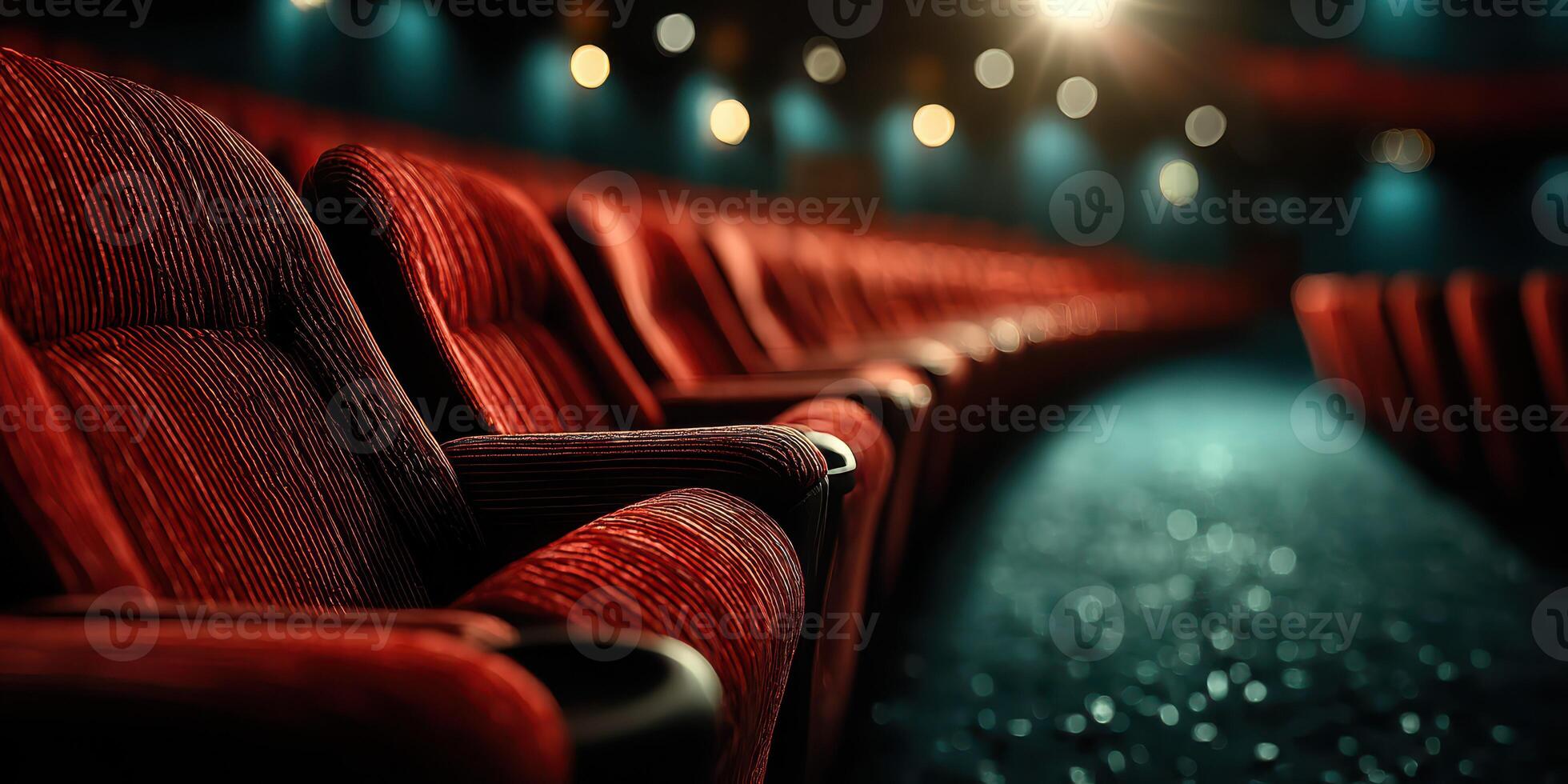 Empty red chairs in a theater setting under soft lighting during a quiet evening performance photo