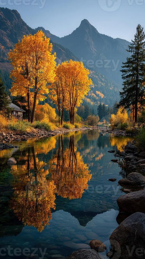 Autumn colors reflect in the tranquil river surrounded by mountains and trees during early morning light photo