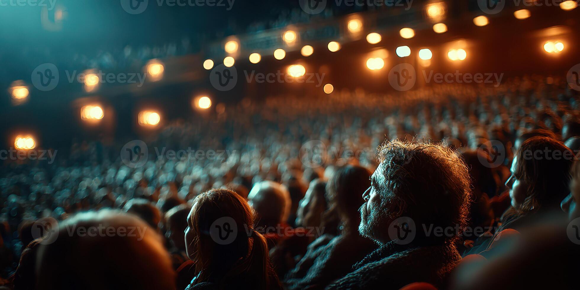 Audience captivated during a theatrical performance in a dimly lit venue on a winter evening photo