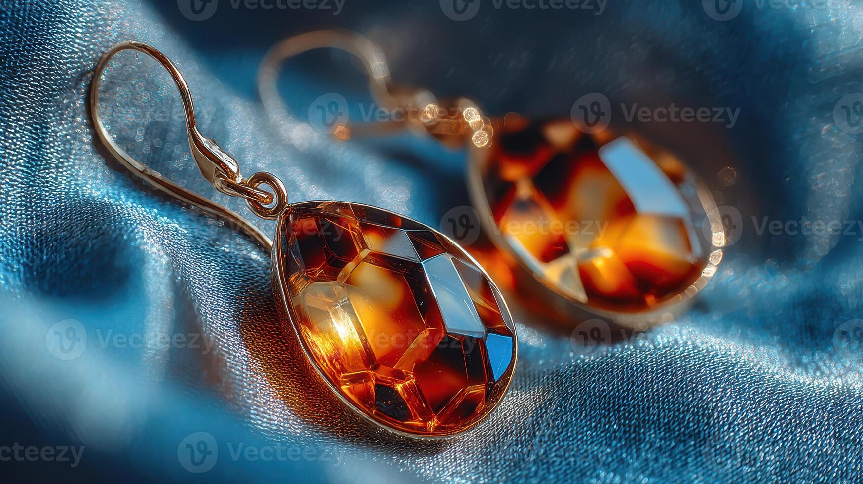 Elegant amber earrings displayed on silky blue fabric showcasing their intricate design and craftsmanship photo