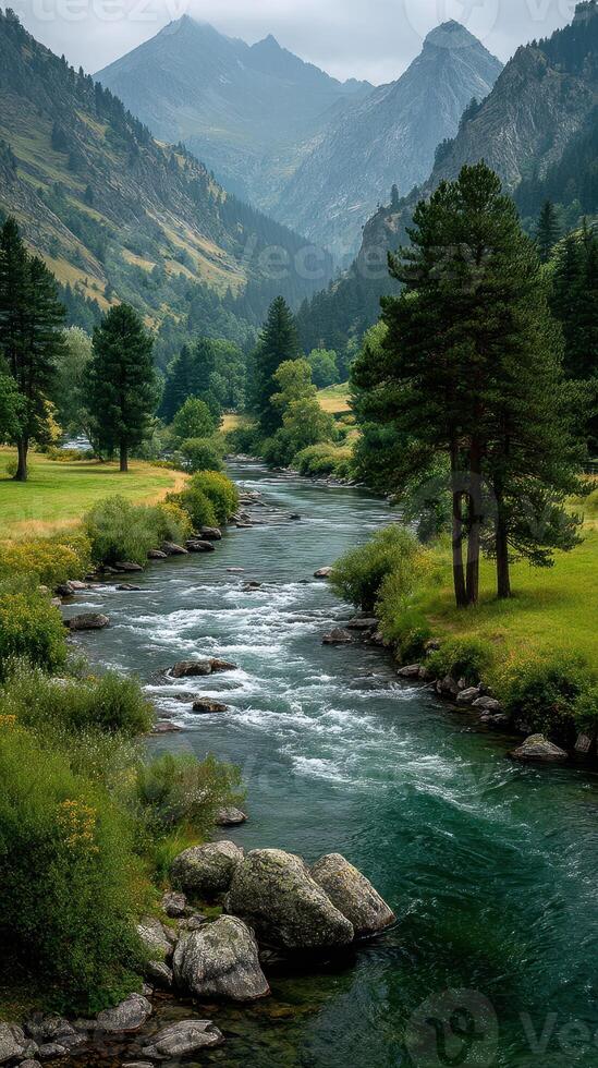 Serene river flows through lush valley surrounded by majestic mountains on a cloudy day photo