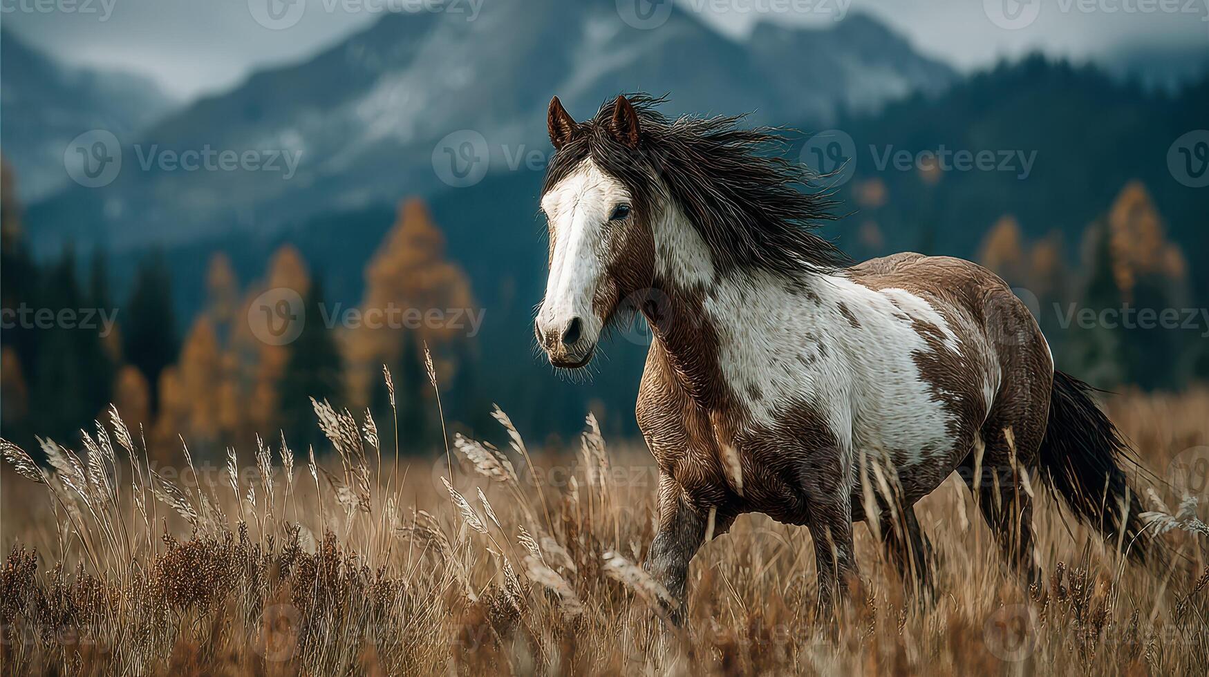 Majestic horse galloping through golden grassland with mountains in the backdrop during autumn photo