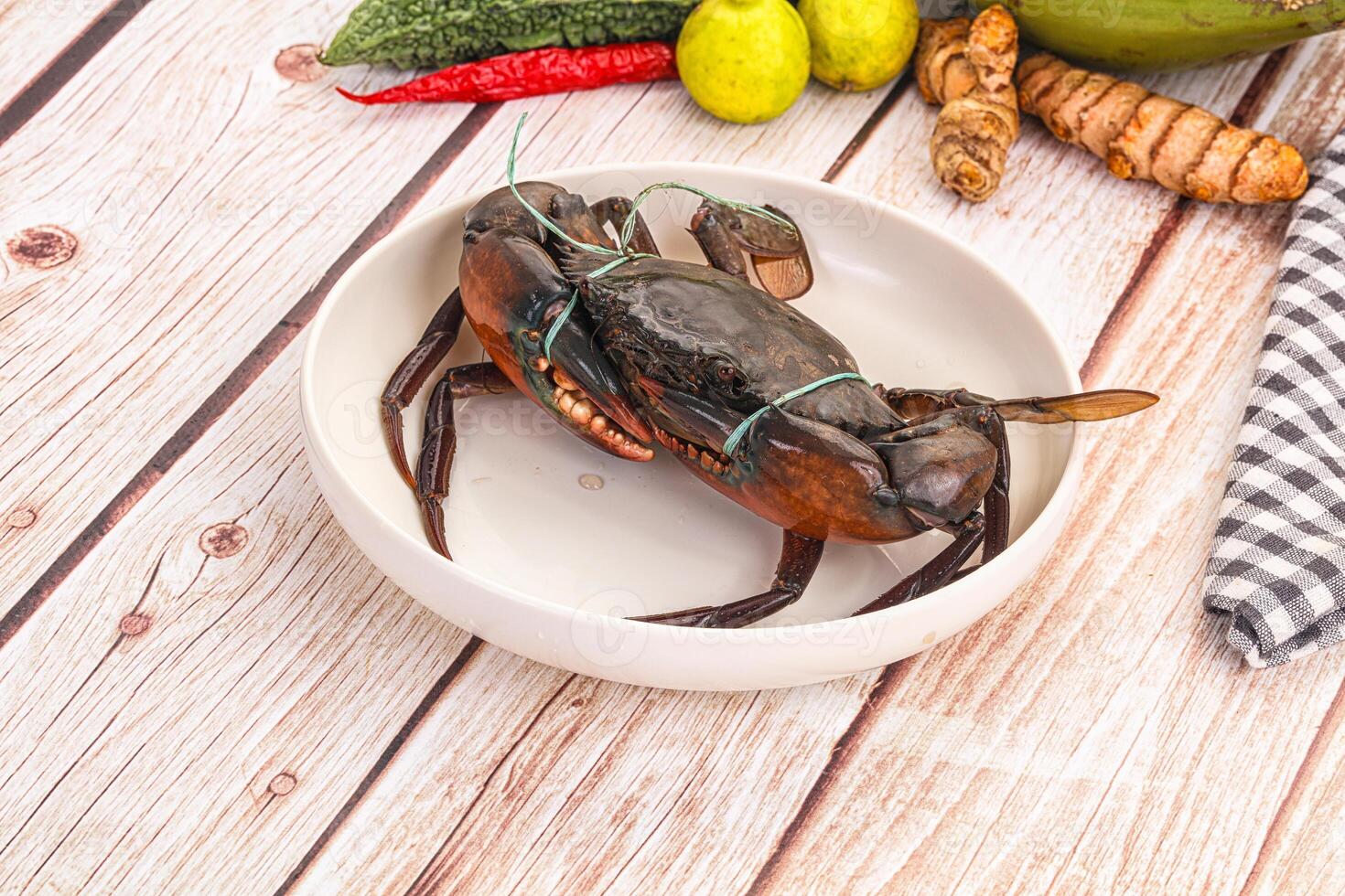 A crab in a bowl with other food on a table photo