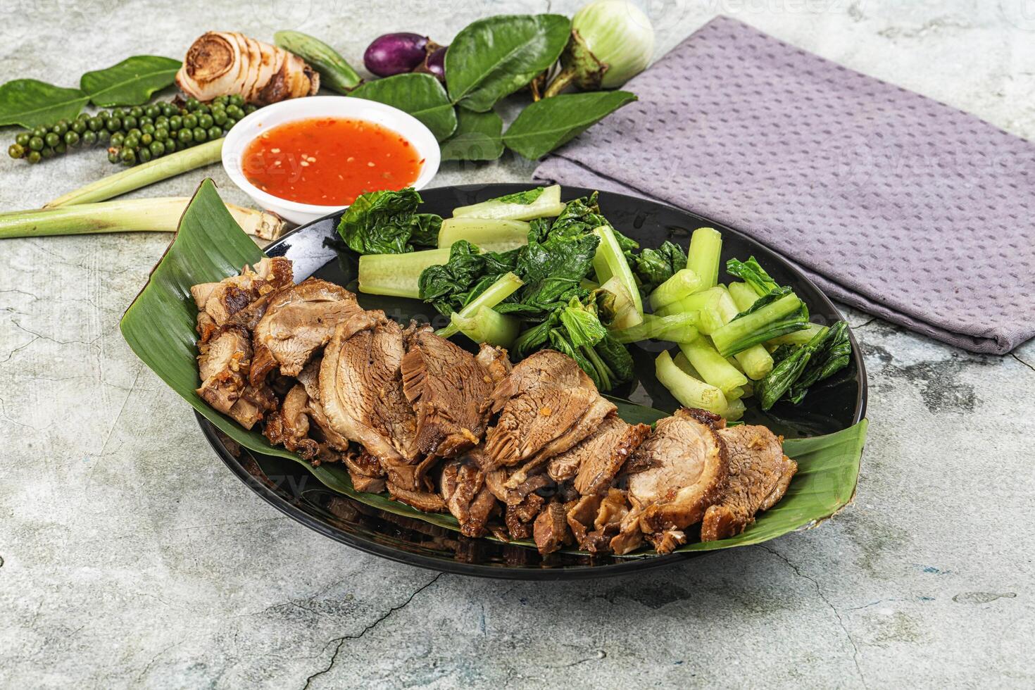 A plate of meat and vegetables with a napkin photo