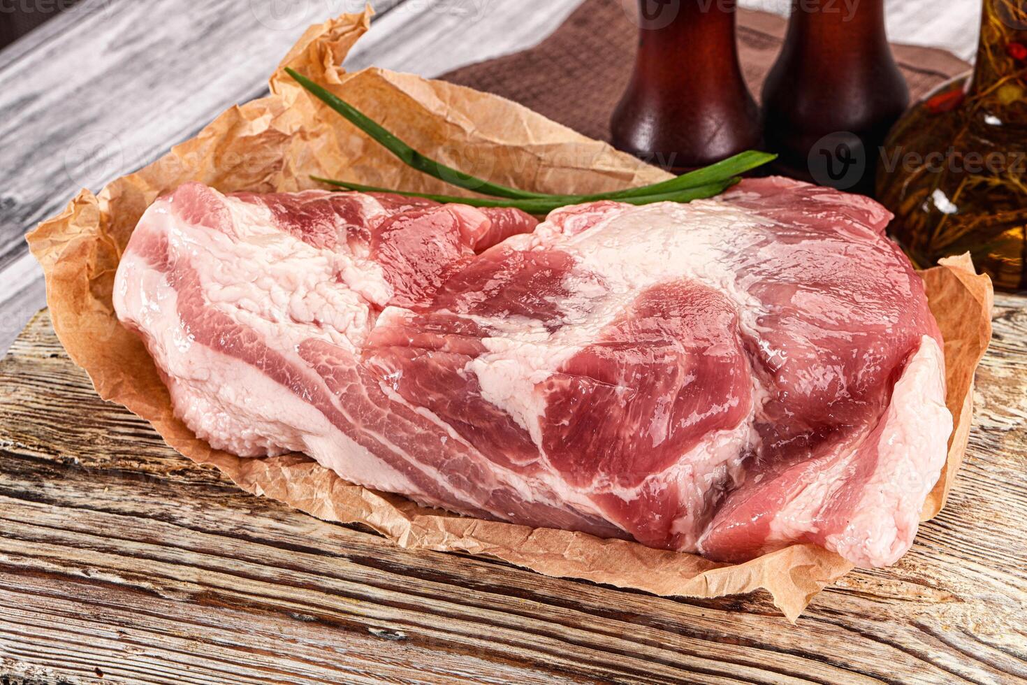 A piece of raw meat sitting on a wooden cutting board photo