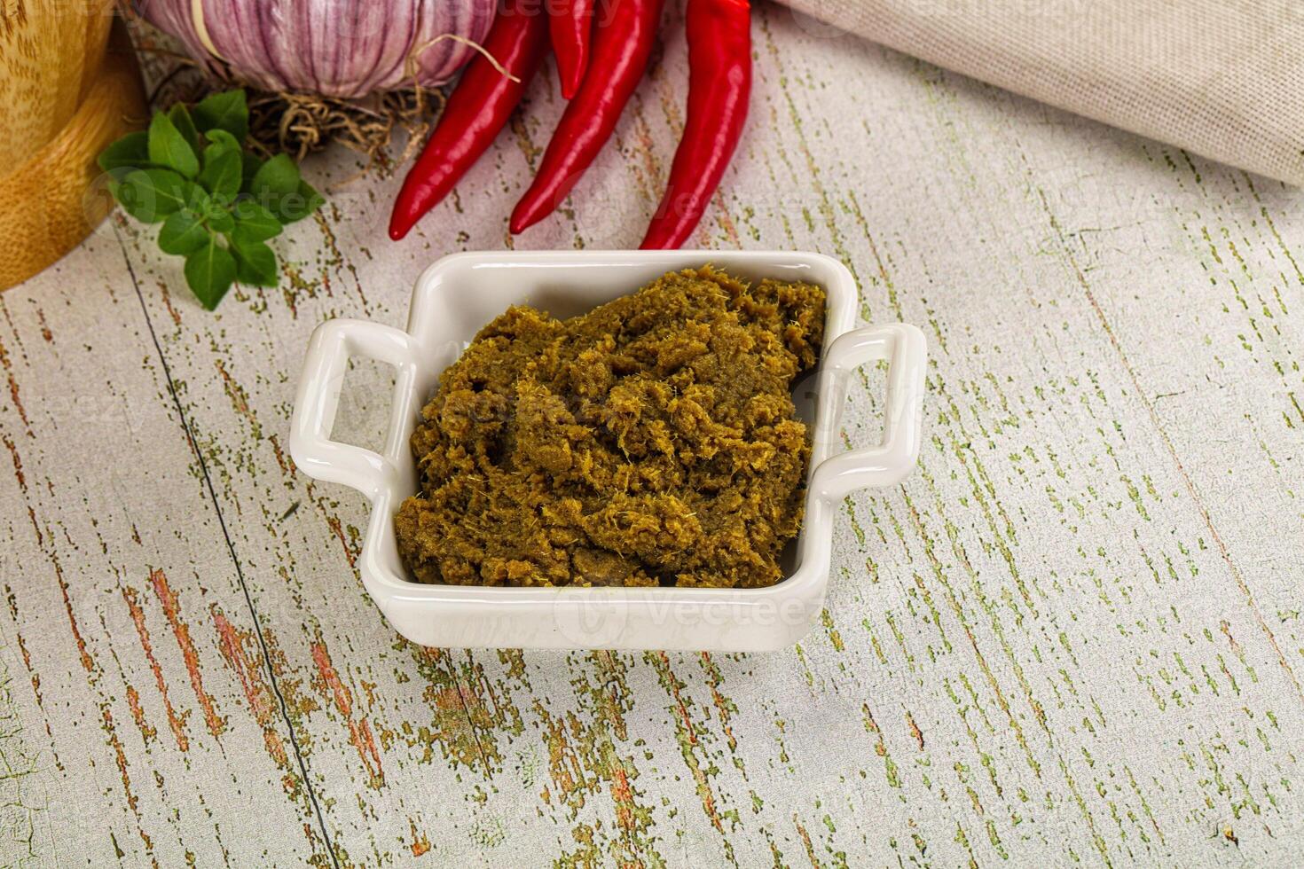 A bowl of green curry paste with spices and herbs photo