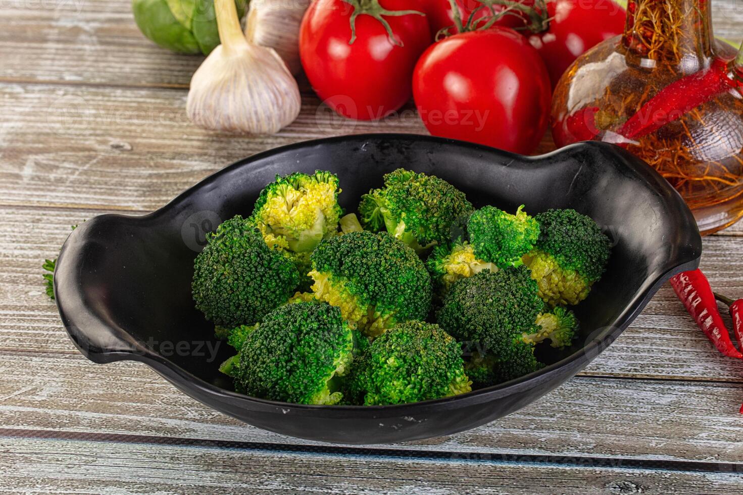 A bowl of broccoli with tomatoes and spices photo