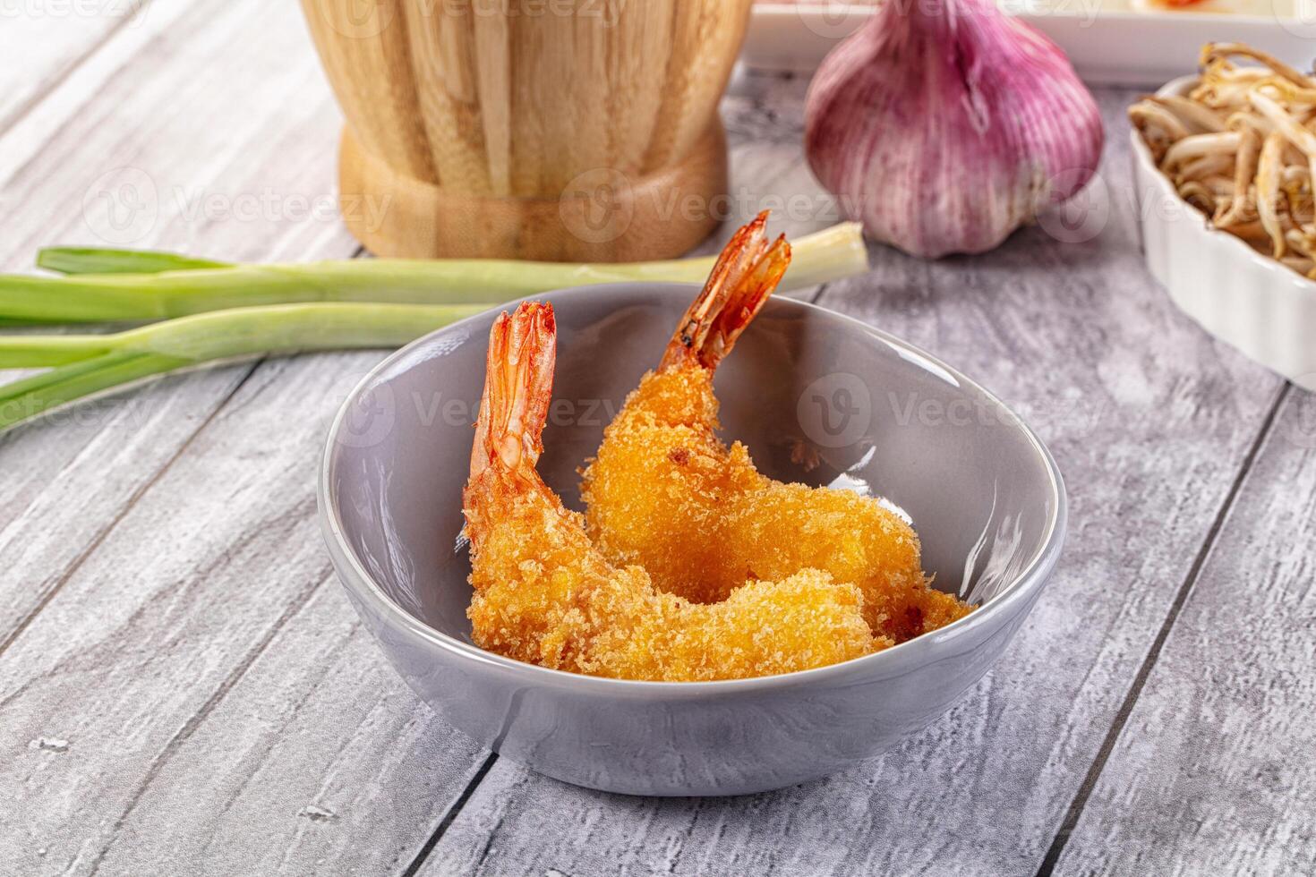A bowl of fried shrimp sitting on a table photo