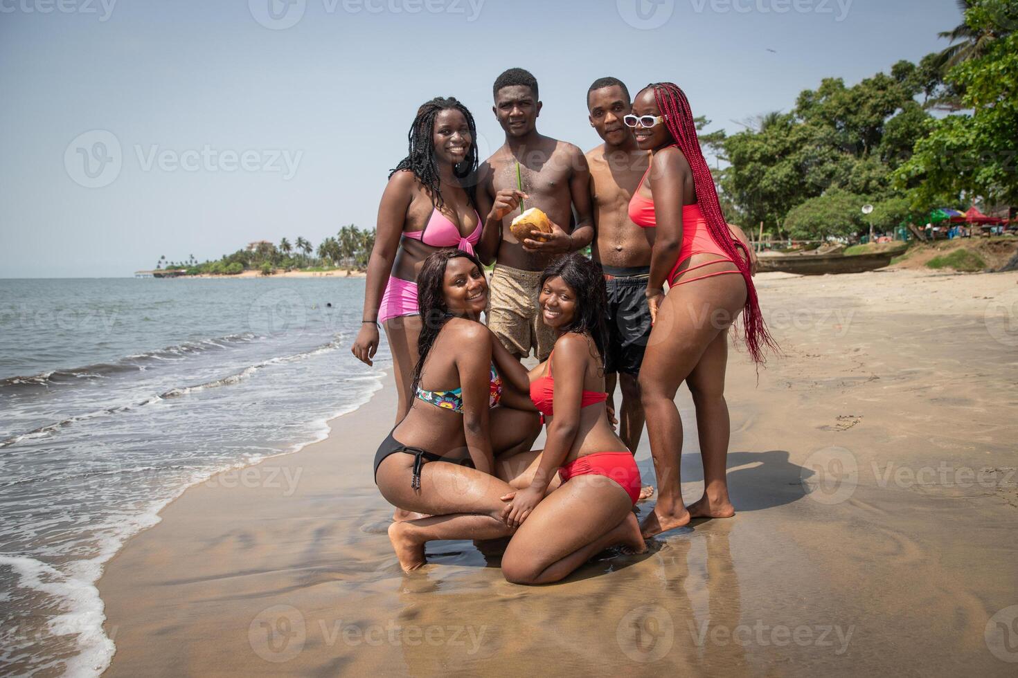 Group of young african men and women at the beach posing and having fun. Togetherness photo