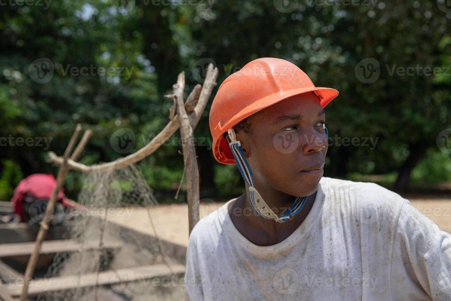 Portrait of a young African fisherman wearing protective helmet and looking around. photo