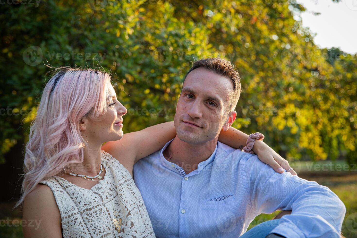 Beautiful loving couple embraced stand still during a walk in the park photo