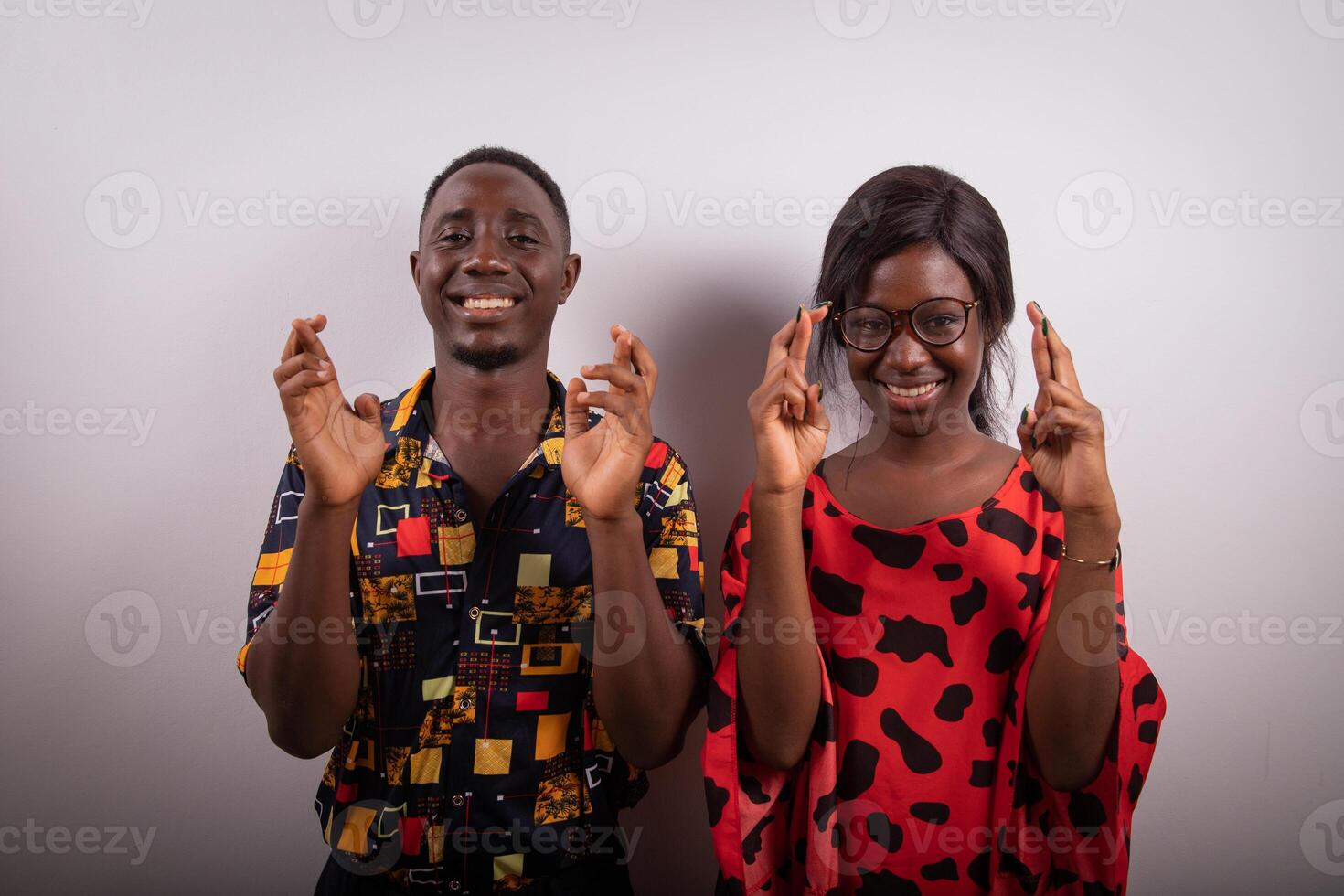 An african boy and girl with crossed fingers, studio photo, concept of good luck and wish photo