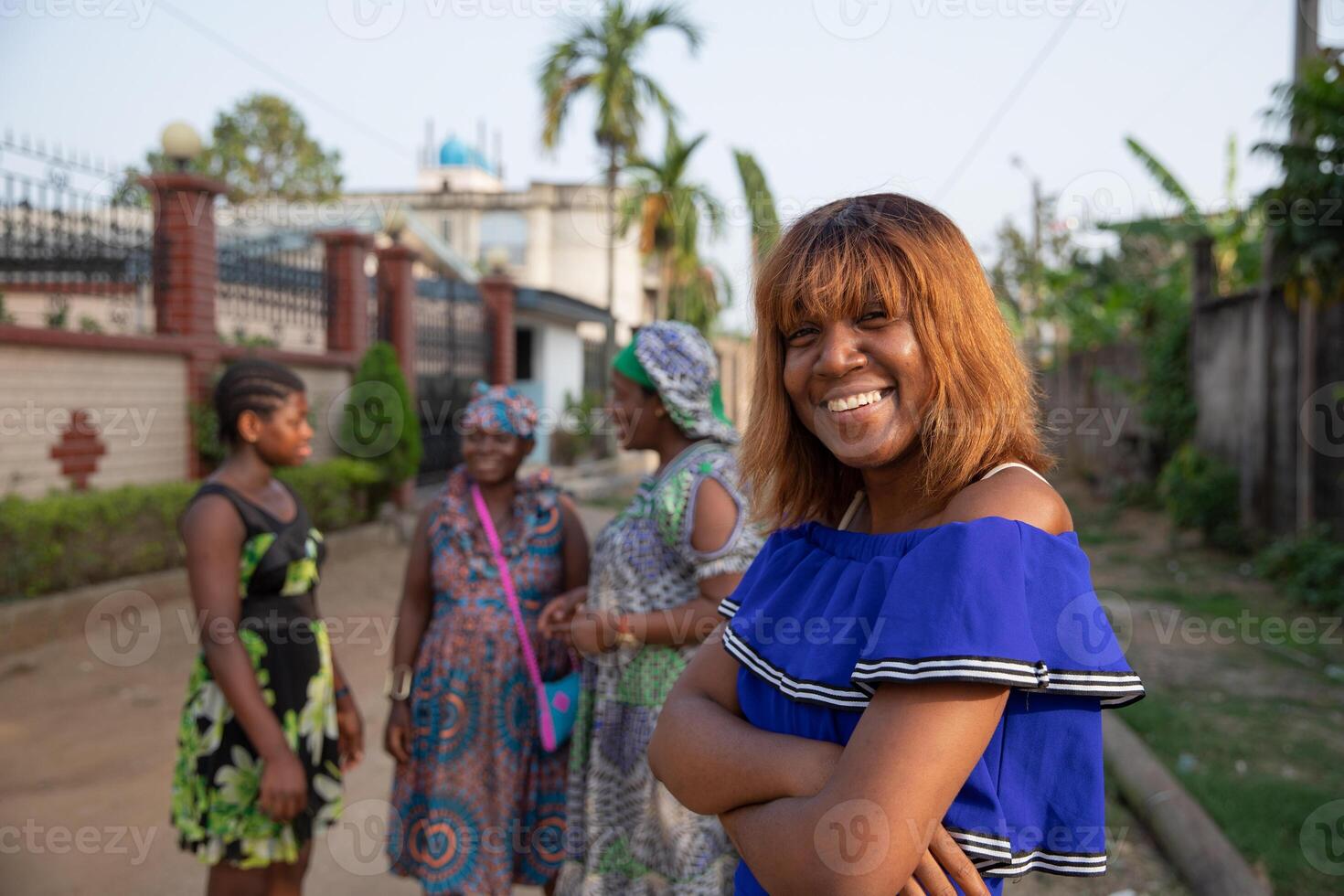 Portrait of an isolated african girl with three other women in the background talking to each other, concept of women in africa photo