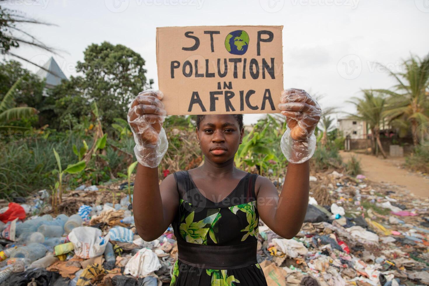 An African girl protests with a sign that reads Stop pollution in Africa, an activist for environmental rights in Africa photo