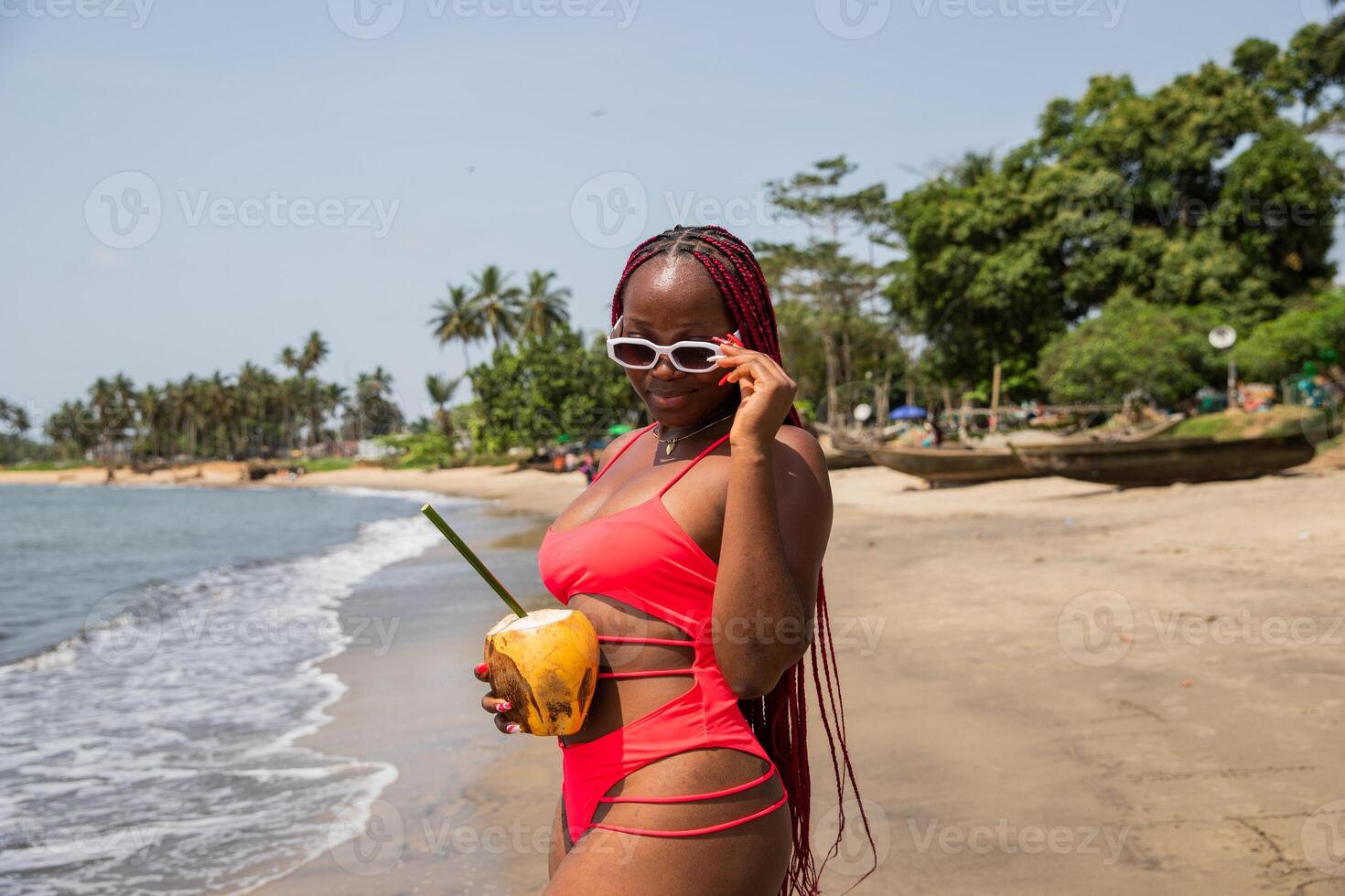 Young black girl wearing sunglasses and with red braids on beach vacation photo